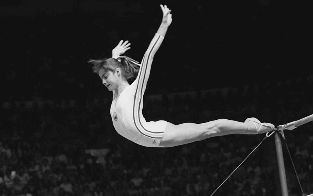 Nadia Comaneci, of Romania, dismounts from the uneven parallel bars at the Olympic Games in Montreal